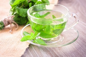 Cup of mint tea and a bunch of mint on the table
