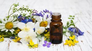 Nature oil with wildflowers on a old wooden background